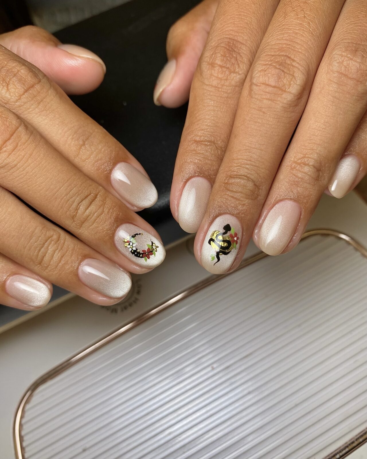Pearl manicure with snake and floral motifs